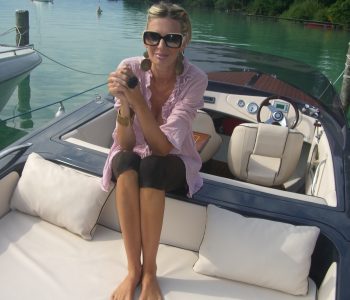 blonde Frau auf Elektroboot am See